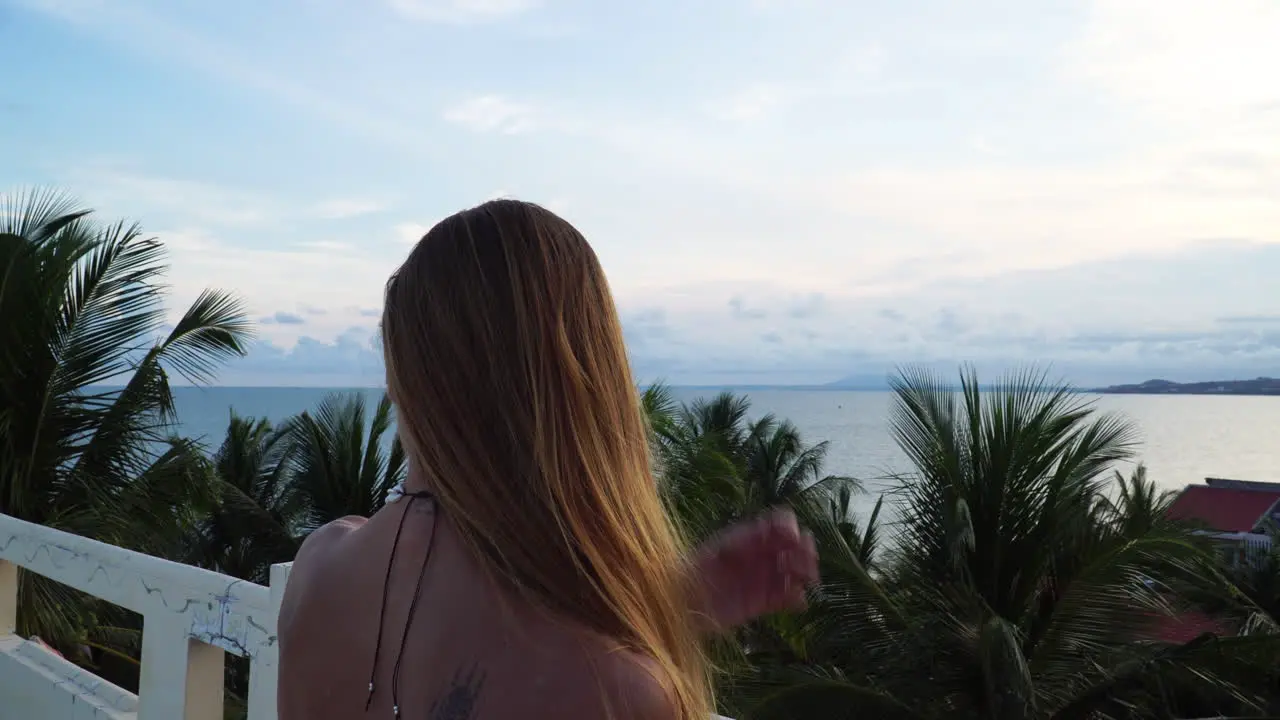 Beautiful blonde girl admiring nature on terrace