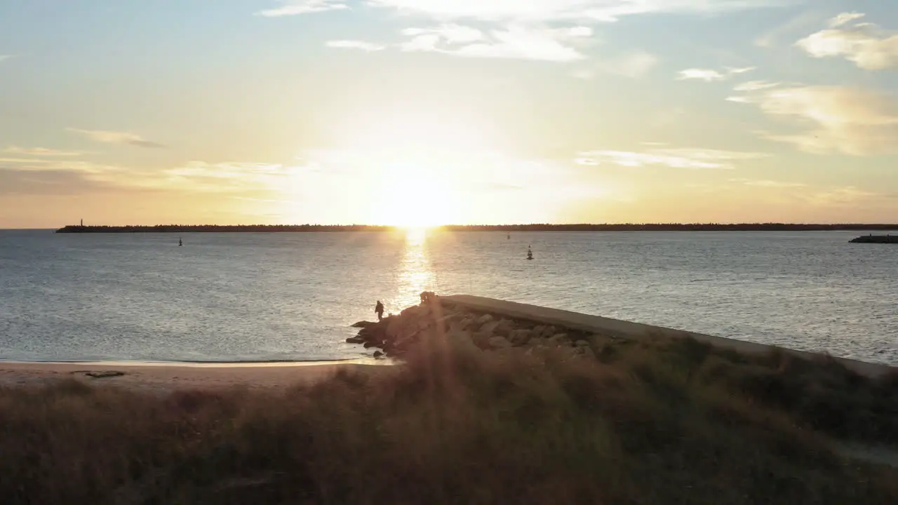 Sunset shrouding the scenery around stone pier in Praia do Cabedelo Viana do Castelo Aerial Wide low angle slide shot