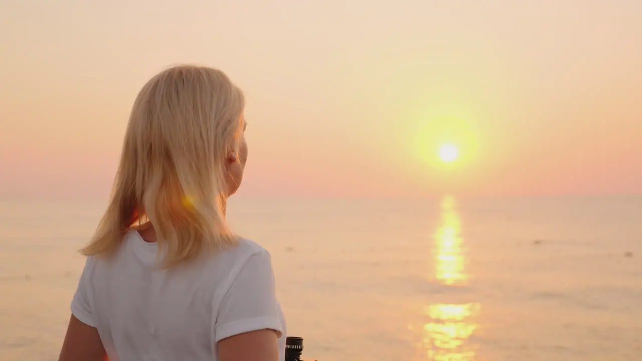 Young Romantic Woman Looks At The Sunrise Over The Sea Of Pink Color Uses Binoculars 4k Video