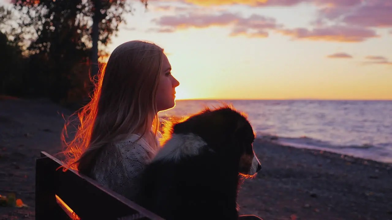 A woman rests with a dog on a bench