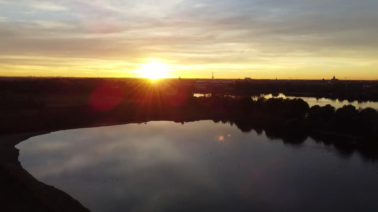 Bright sunshine during golden sunset over lake landscape of Belgium aerial view