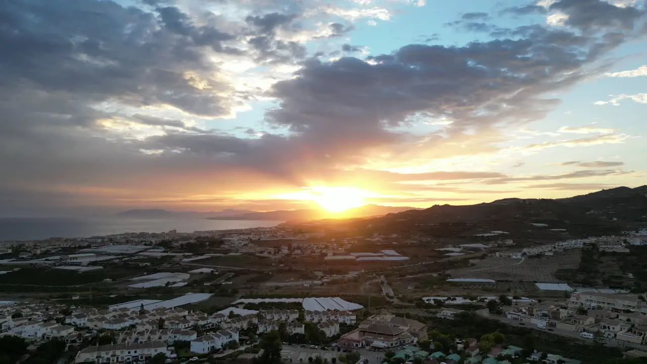 Beautiful sunset shot from drone rising up over Spanish countryside with clouds over sea