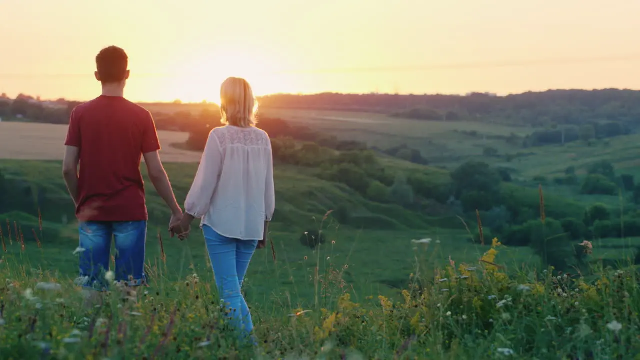 A Little Cool Girl Runs To Meet The Sunset To Her Family Back View