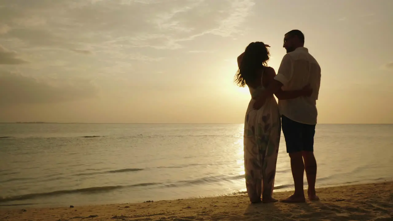 A Young Couple Is Admiring The Sunset Over The Sea Rear View 4k Video