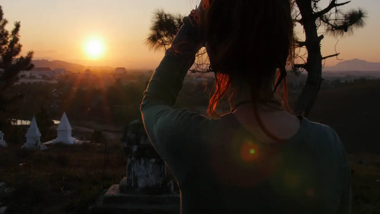 A female tourist enjoying and admiring the beautiful sunset over the Phonsavan Village in Laos Wide shot