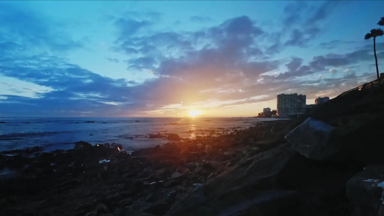 Dramatic time lapse of cloudy sunset at a rocky beach