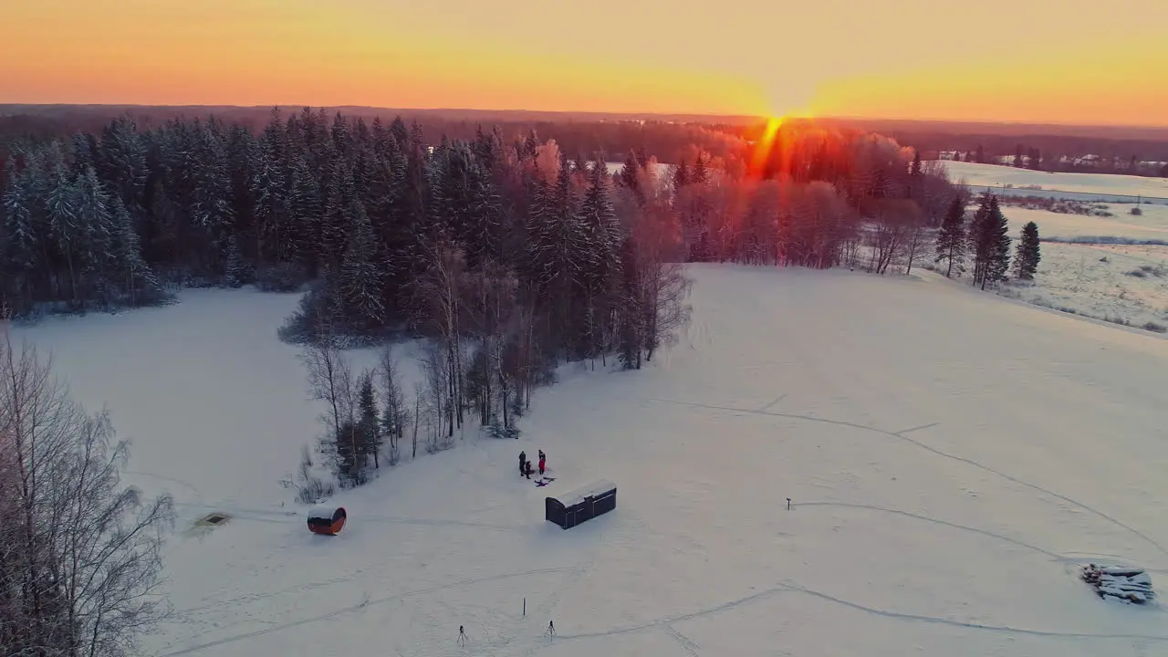 People playing on snow with glowing winter sunlight