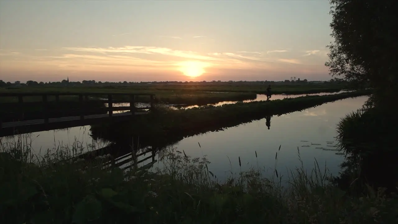 Man Running In Rural Landscape At Sunset wide static shot