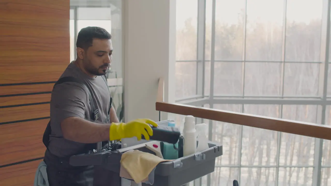 Arabic Cleaning Man Carrying A Cleaning Cart Inside An Office Building