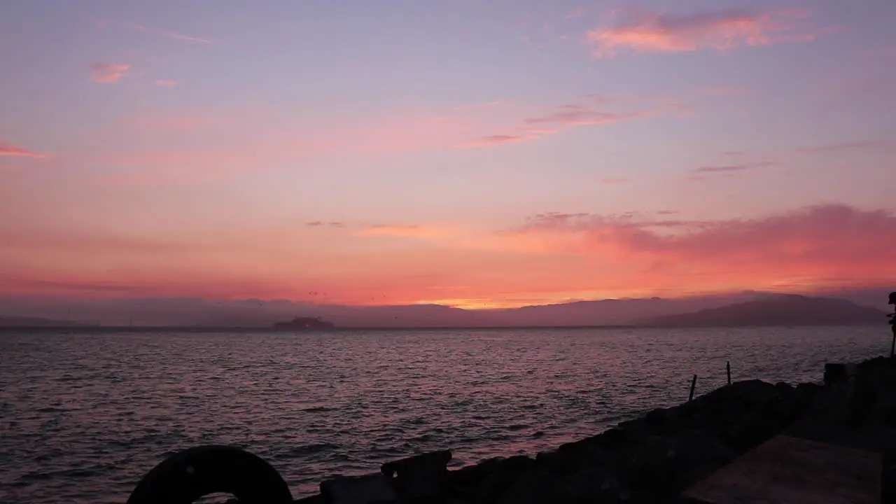 Golden Summer Sunset over the San Francisco Bay with Alzatraz the Mountains and Golden Gate Bridge on the horizon