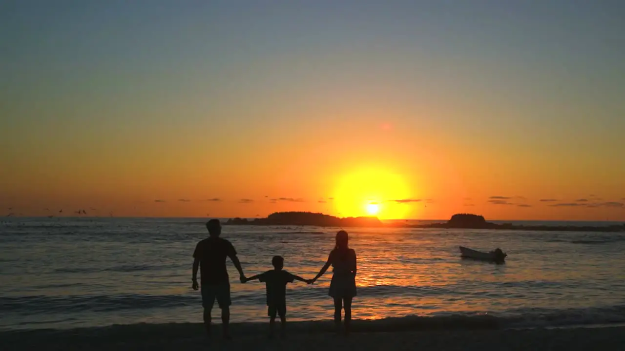 Family on beach vacation enjoying a peaceful and relaxing ocean sunset