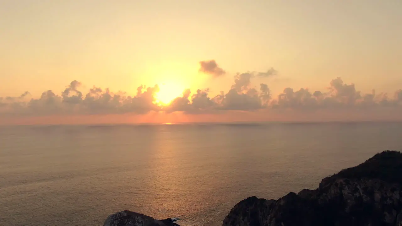 Orange Sunset Glow Behind Clouds Over Tranquil Sea At Maruata Beach Michoacan Mexico