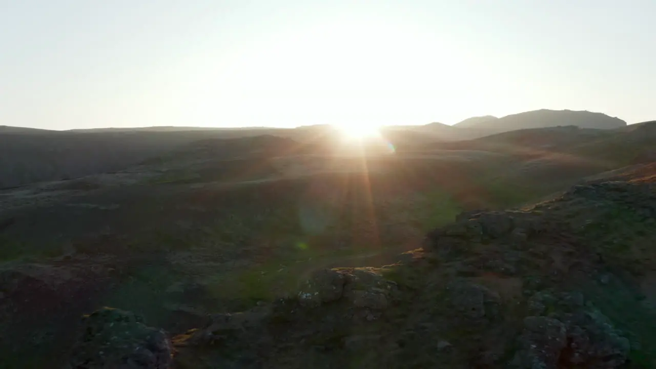 Flying toward birds eye backlit of Iceland highlands Aerial view top view over rocky formations hill in backlight at sunset No people Amazing on earth