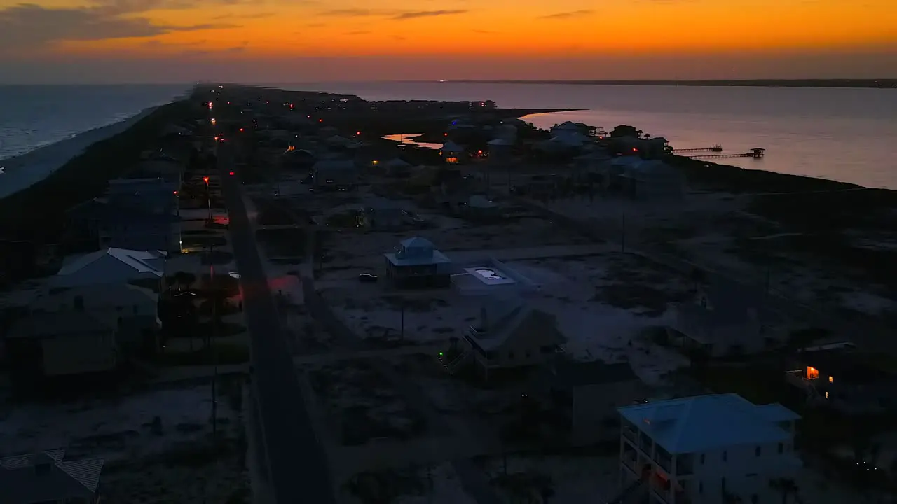 A drone quietly flies over a sleepy beach town at sunset