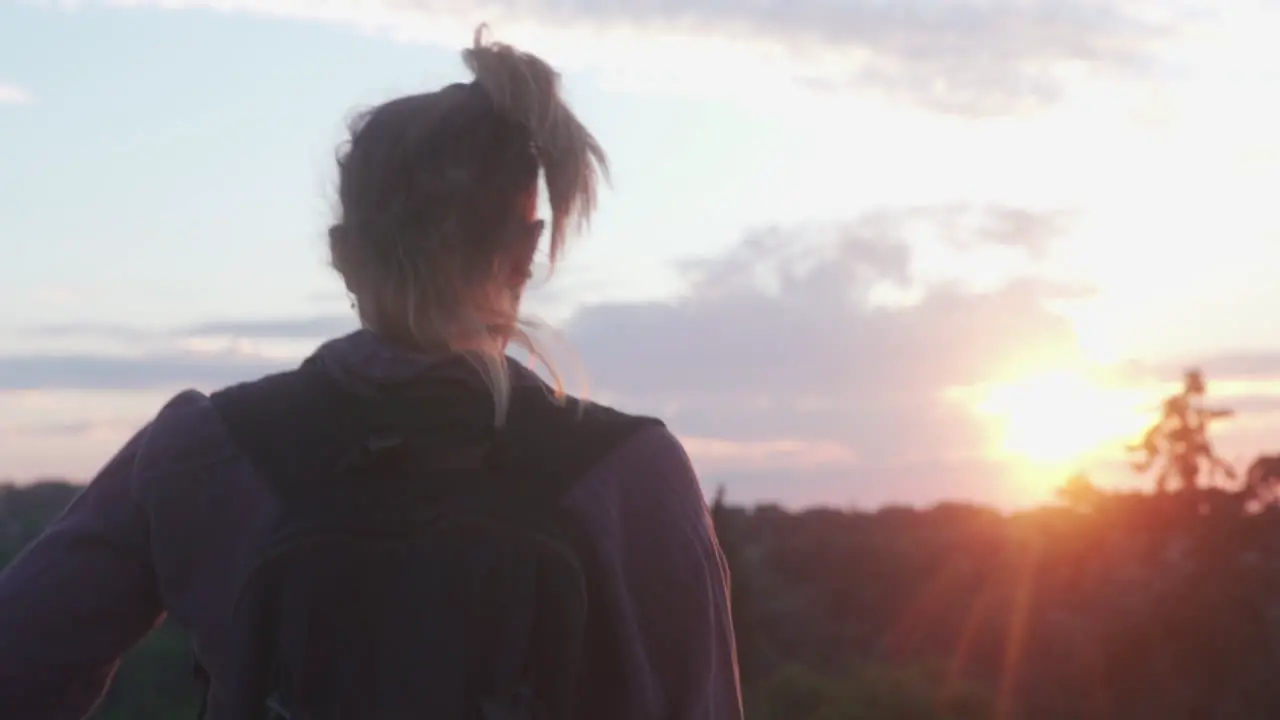 Female walks through natural landscape in the sunset