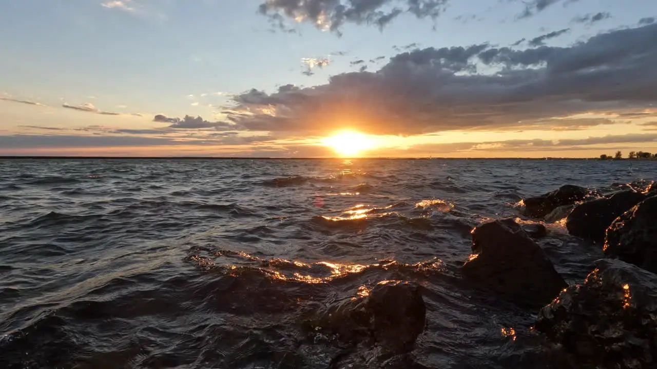 A beautiful evening on the shore of a lake with the waves rolling against the shore