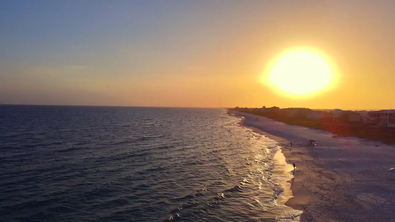 A cinematic flight above a powder white beach in the Florida Panhandle at sunset