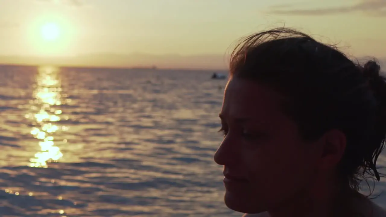 Close up on caucasian greek woman's face with beautiful sunset at sea of Kalamata Peloponnese  Greece