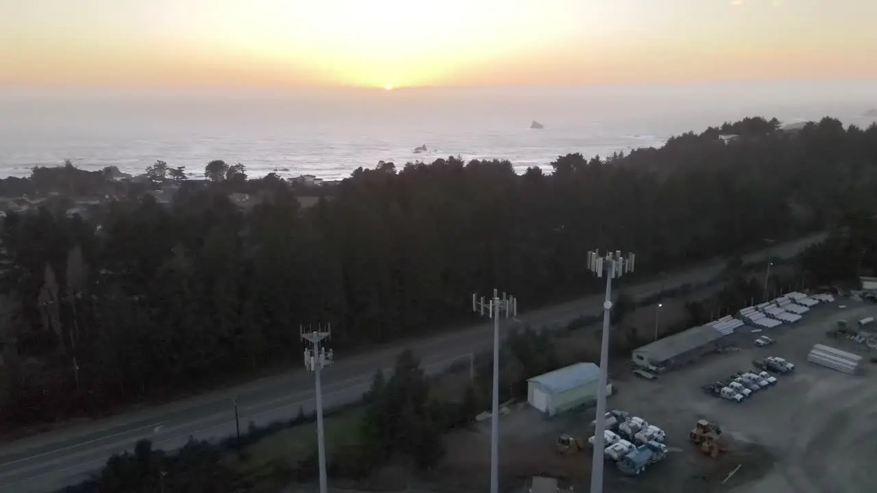 Cell towers and sunset over sea in background