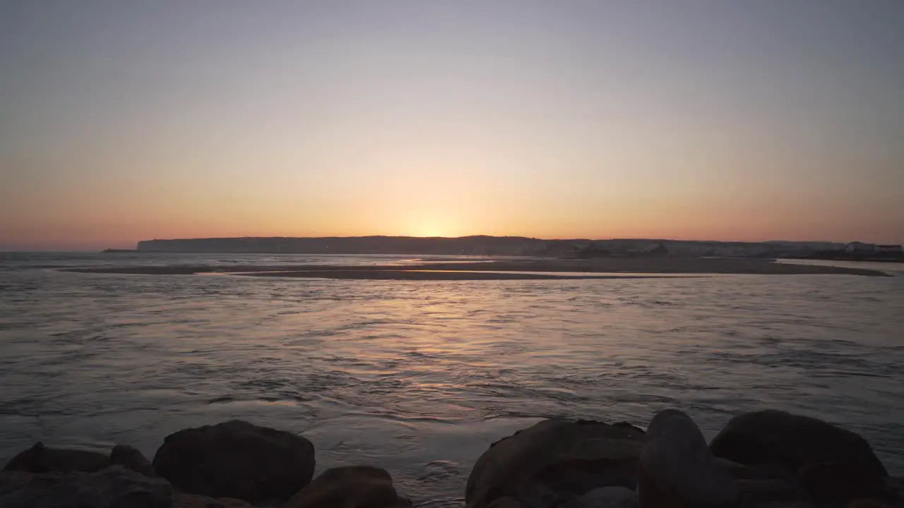 River flowing into the sea during the sunset in the coast of Cadiz Spain