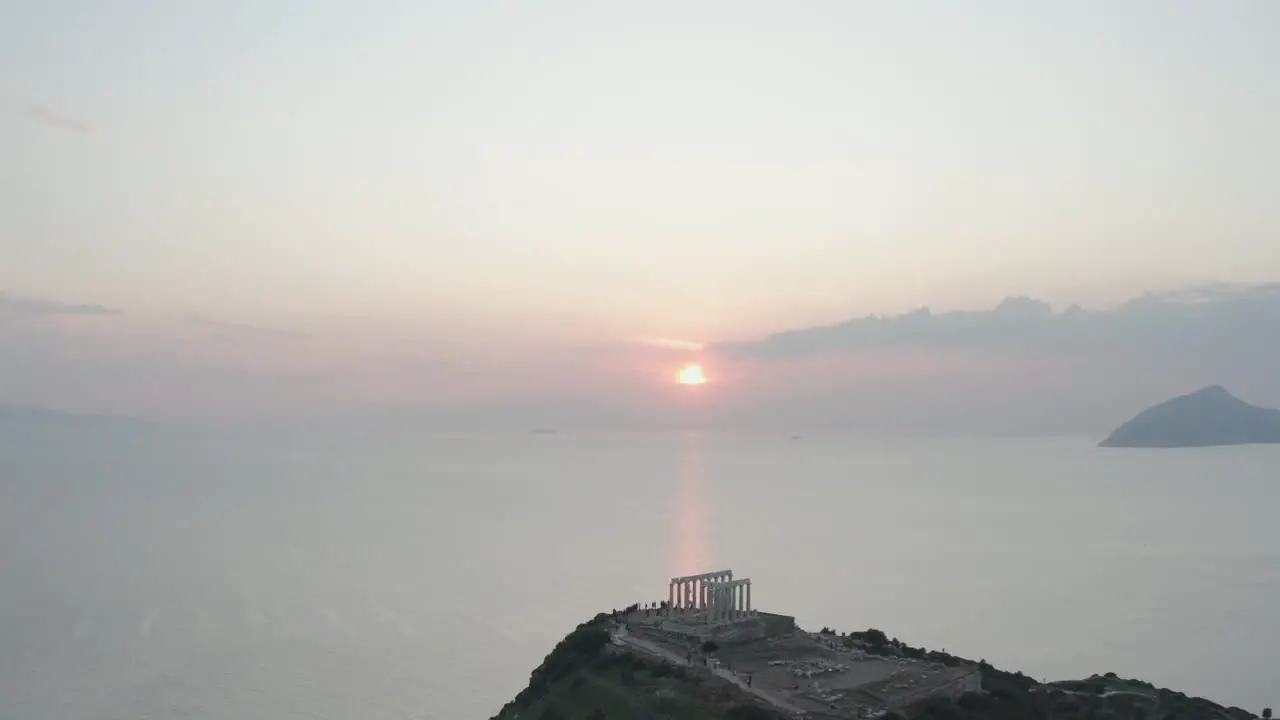 Drone shot of ancient ruins in Greece with sun setting in background