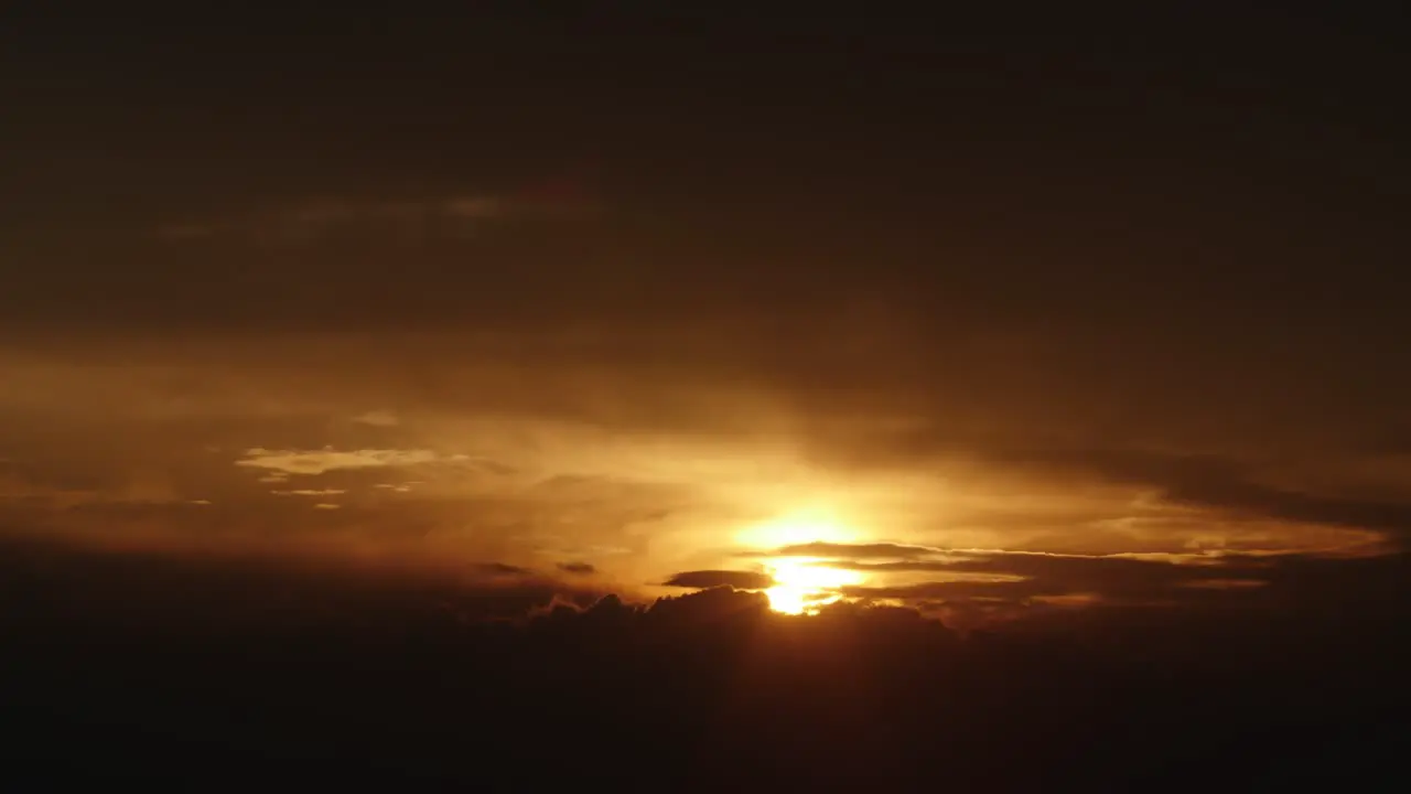 Beautiful sunset in golden colors behind the fluid movement of clouds