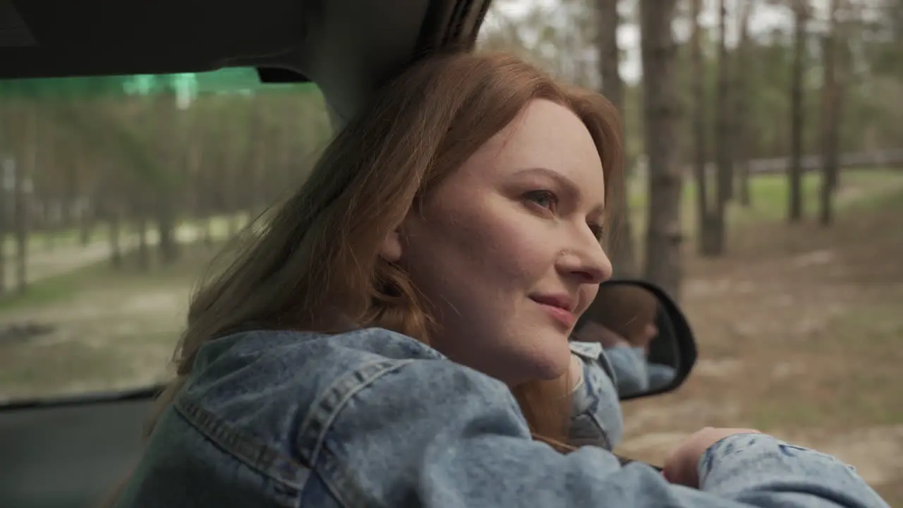 Red Haired Female Enjoys A Drive Through The Countryside From The Window Of The Car 3