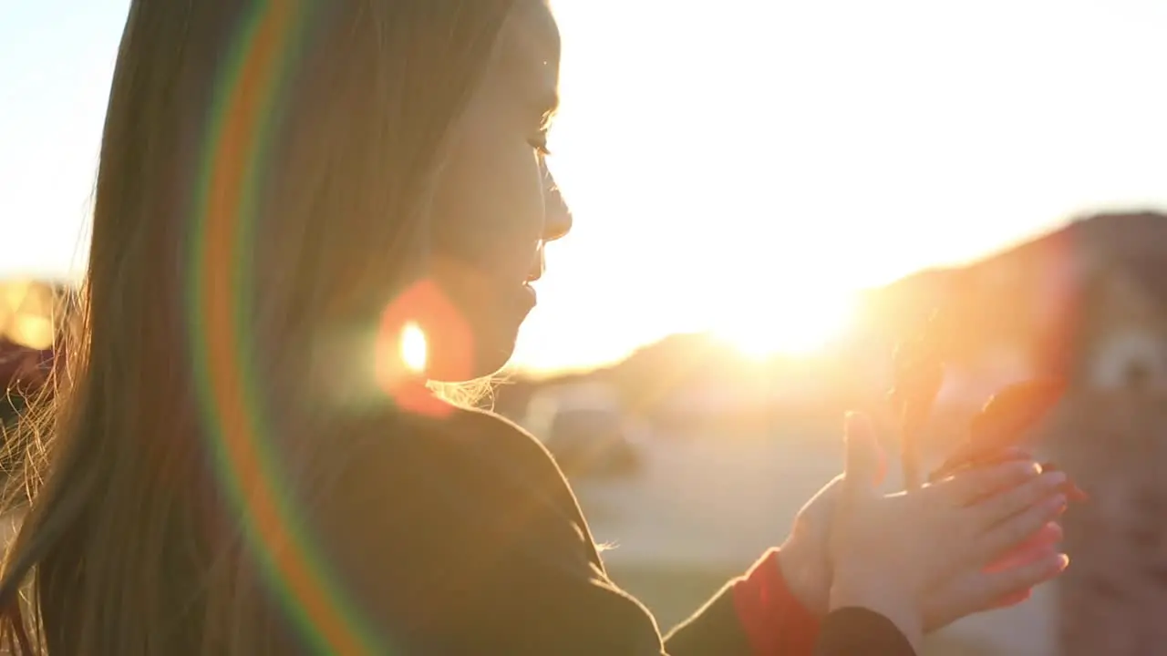 Little girl playing with leaf in the setting sun sunlight orange sky and lens flare nature b roll