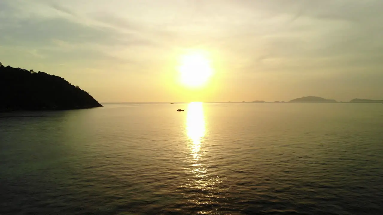 Backward flight over the ocean with golden sunset on the background