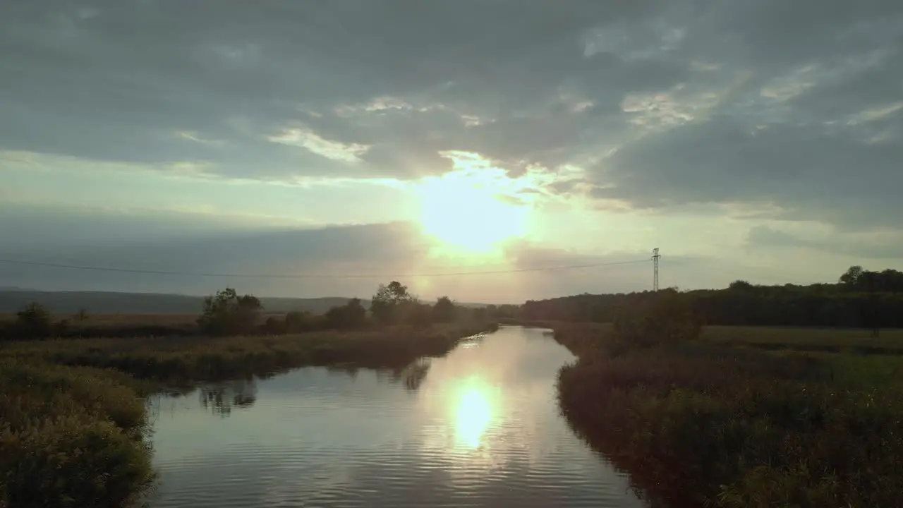 Aerial shot of river in green valley at sunset-1