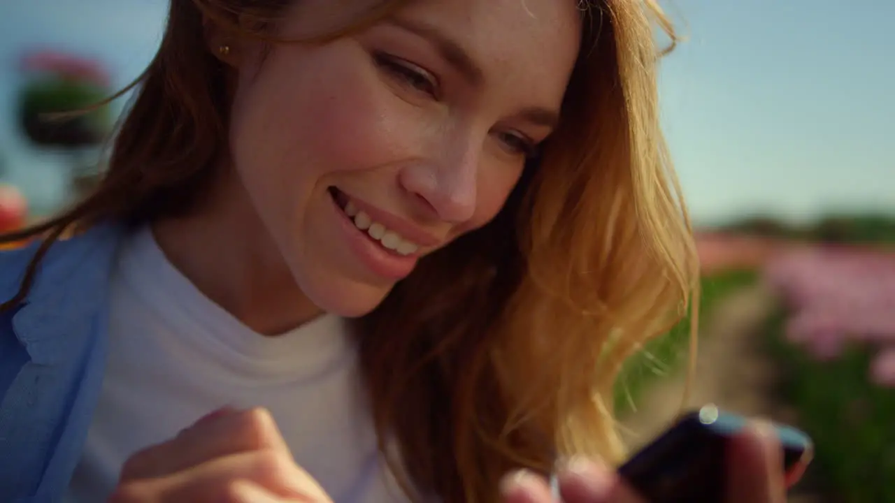 Happy girl sliding cellphone screen outside Emotional girl communicating online