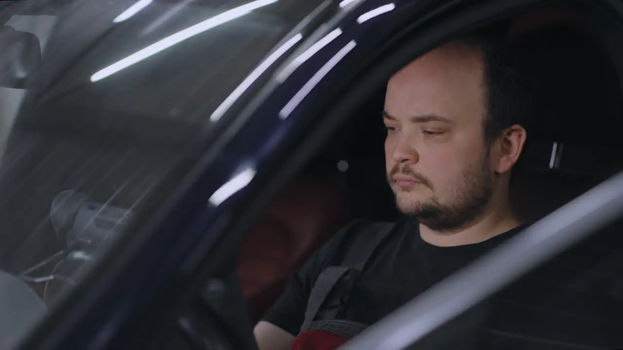 male Mechanic Uses a Tablet Computer with an Augmented Reality Diagnostics Software Specialist Inspecting the Car to Find Broken Components Inside male uses laptop for diagnostics vehicle