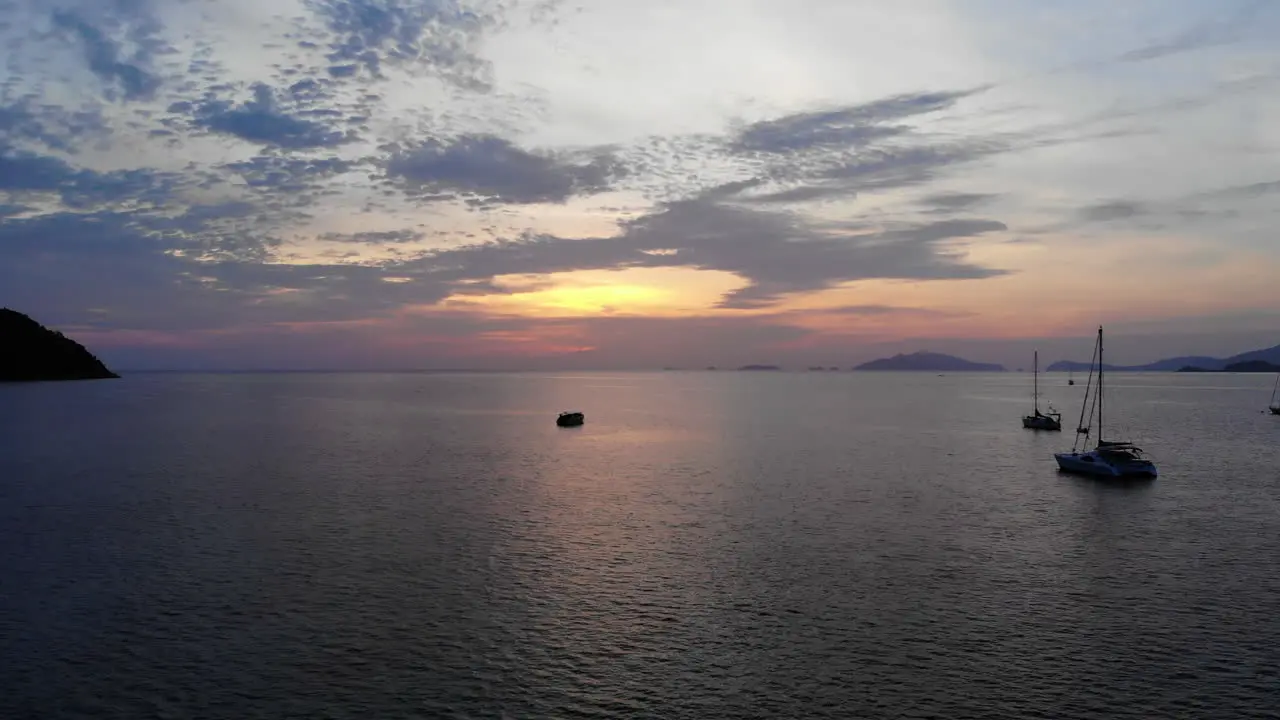 Aerial view of the ocean with a boat and a colorfull sunset