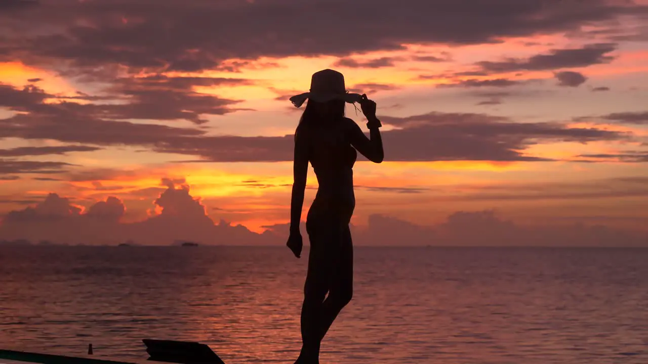 Woman posting by the poolside with twilight background Silhouette shot