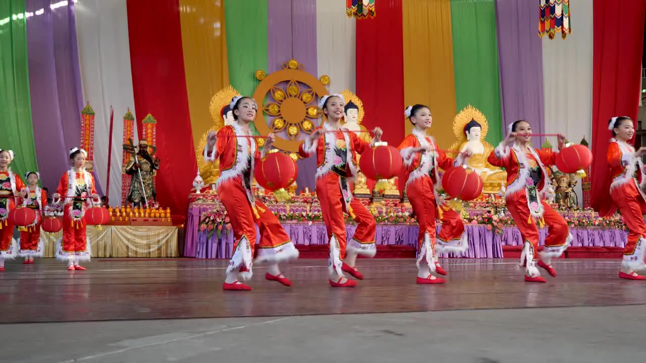 Chinese kids dancing with traditional Chinese lantern during buddha birthday festival brisbane 2018 Chinese kids wearing traditional clothes and dancing in front of buddha statue