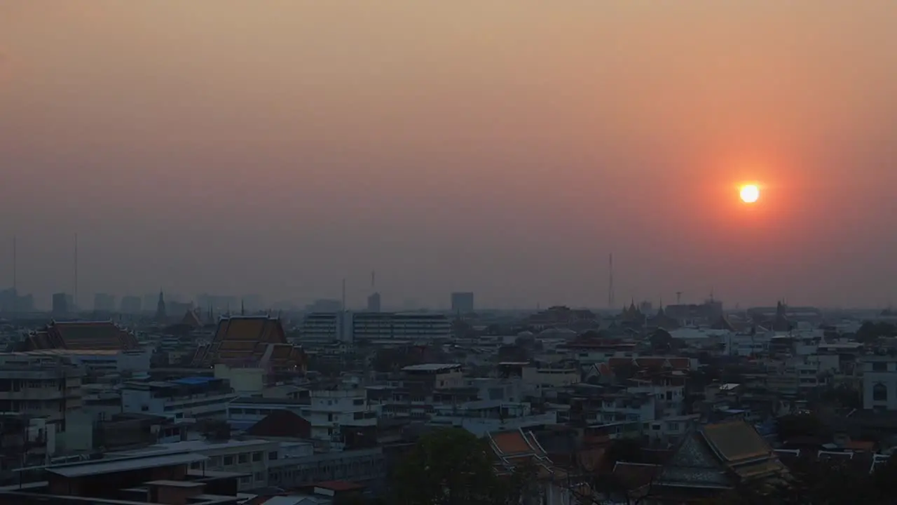 Sunset view on Bangkok city from Golden Mountain Temple Wat Saket in Thailand red sky on fire