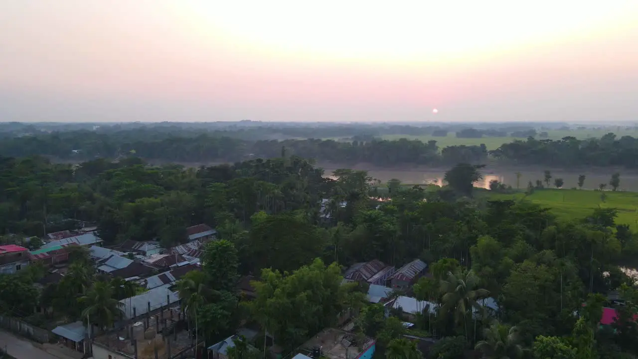 Small village slum community beside river at sunrise in Asia