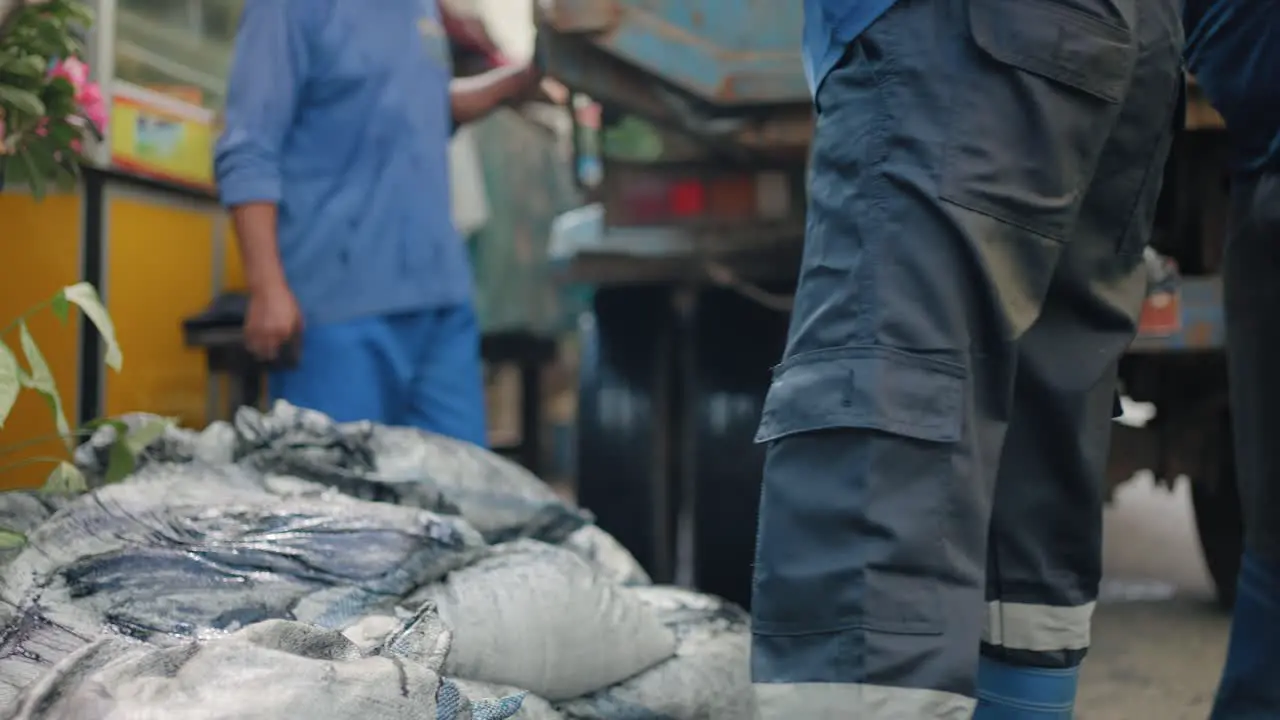 Close Up Shot of Workers Hands Loading Bags into Truck