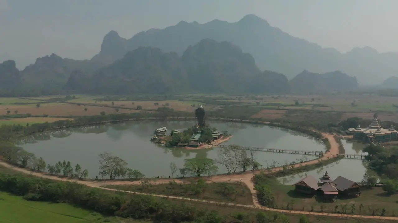 Ancient monastery with artificial lake and majestic mountains in background