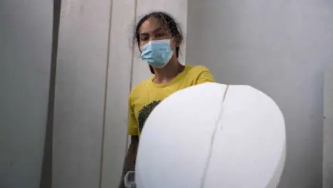 Handheld Long Shot of a Surfboard Shaper Using a Power Tool On Polystyrene Surfboard