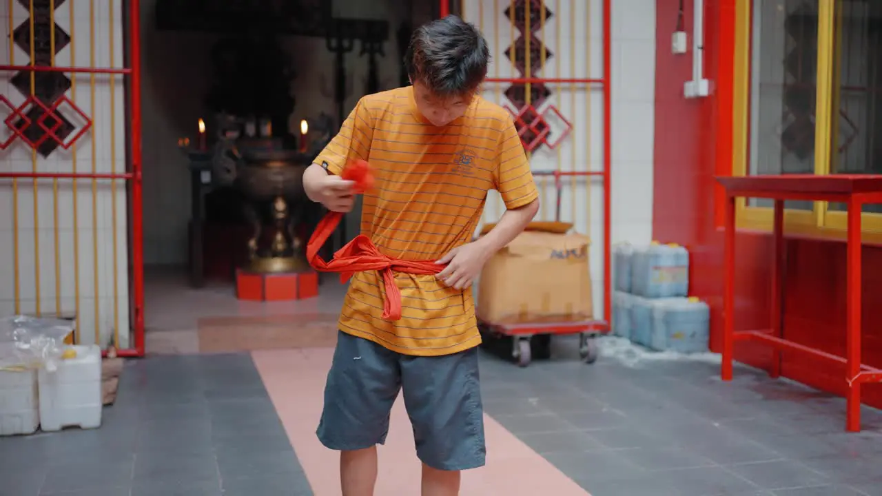 Tracking Shot of Young Boy Tying Fabric