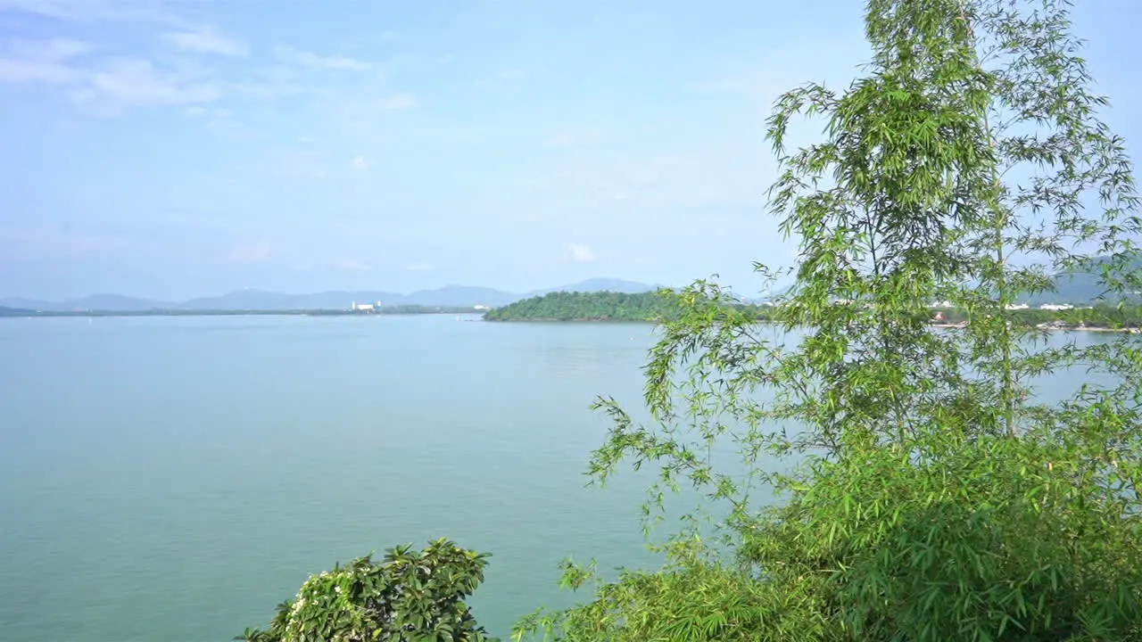 Pan across the ocean bay surrounded by thick green vegitation