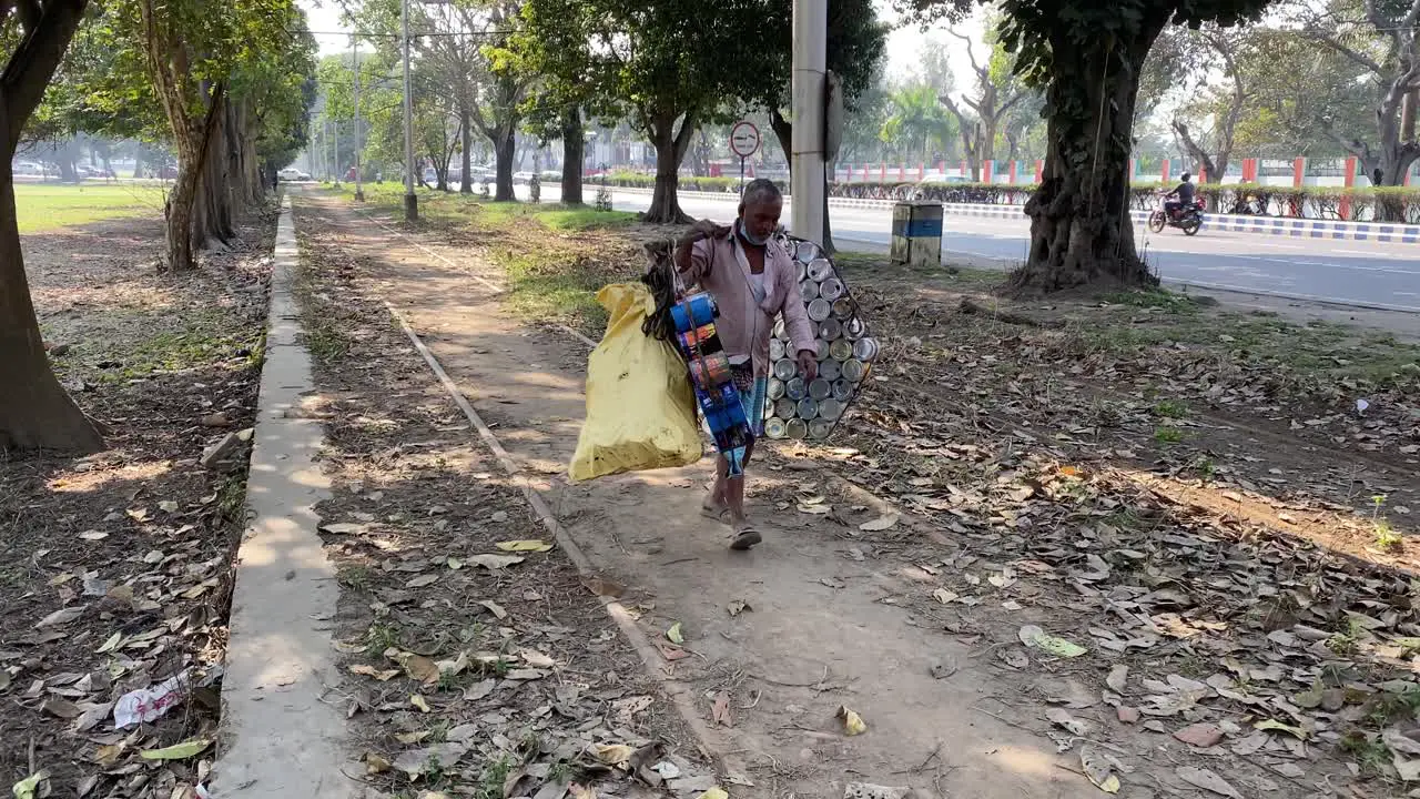 A rag picker carrying empty paint bucket for sale in Kolkata India