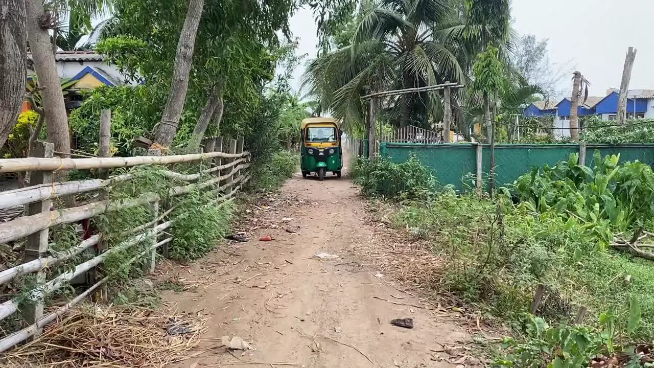 An auto coming towards the camera in an Indian village road