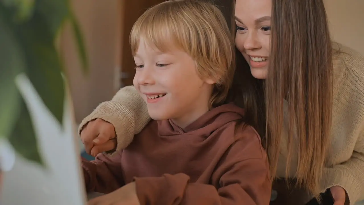 Little Boy And Older Sister Watching A Movie With Laptop And Having Fun At Home