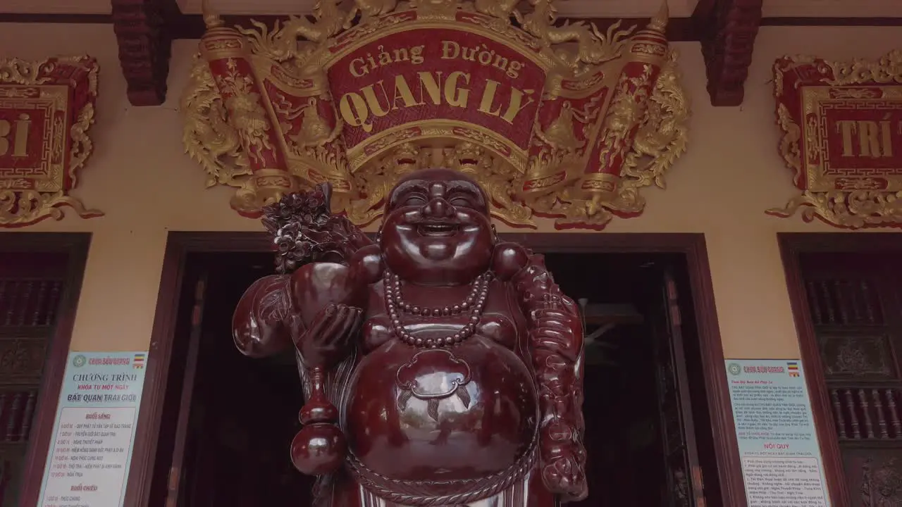 Beautifully carved Large Wooden Buddha traditional at entrance to Buddhist Temple in Suburban area of Ho Chi Minh City Vietnam