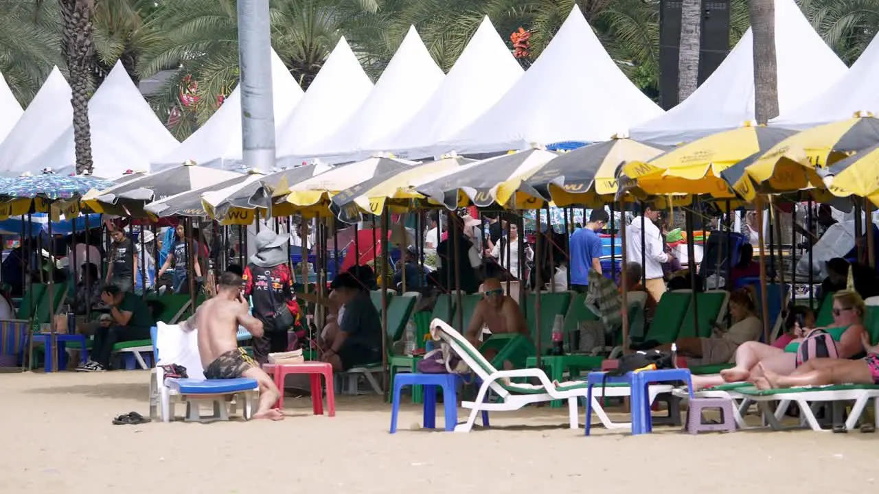 Local and foreign tourists lazing and strolling around in Pattaya Beach in Chonburi province in Thailand