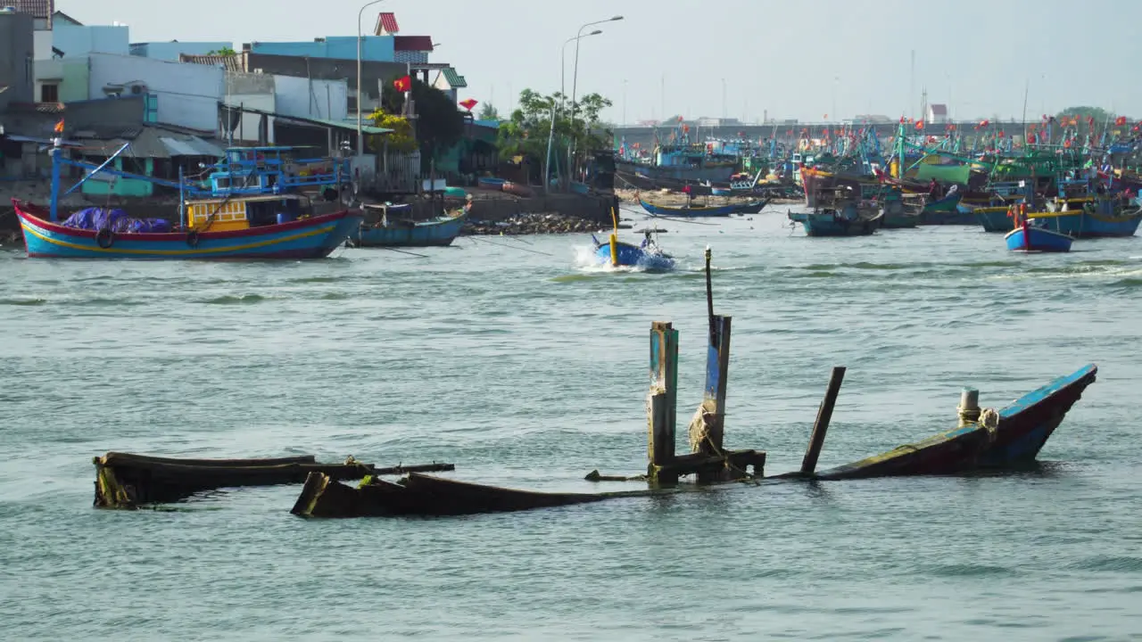 Old capsized Vietnamese fishing boat in fishing harbor Southeast Asia