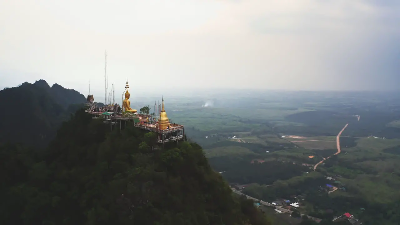 Buddhist Tiger cave temple on mountain top above Thailand countryside