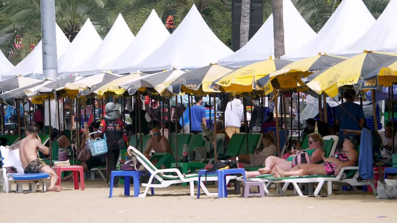 Tourists lying on beach chairs at the beachfront of Pattaya in the province of Chonburi in Thailand